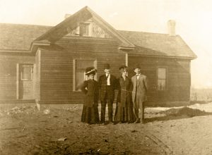 Image of the Arrington house with 4 people in the front