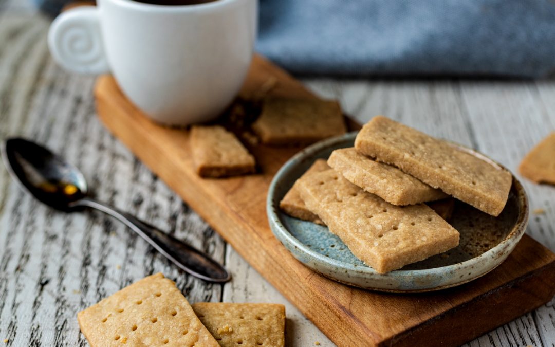 3 ingredient Scotch Shortbread Cookies piles on a plate with coffee and a spoon.