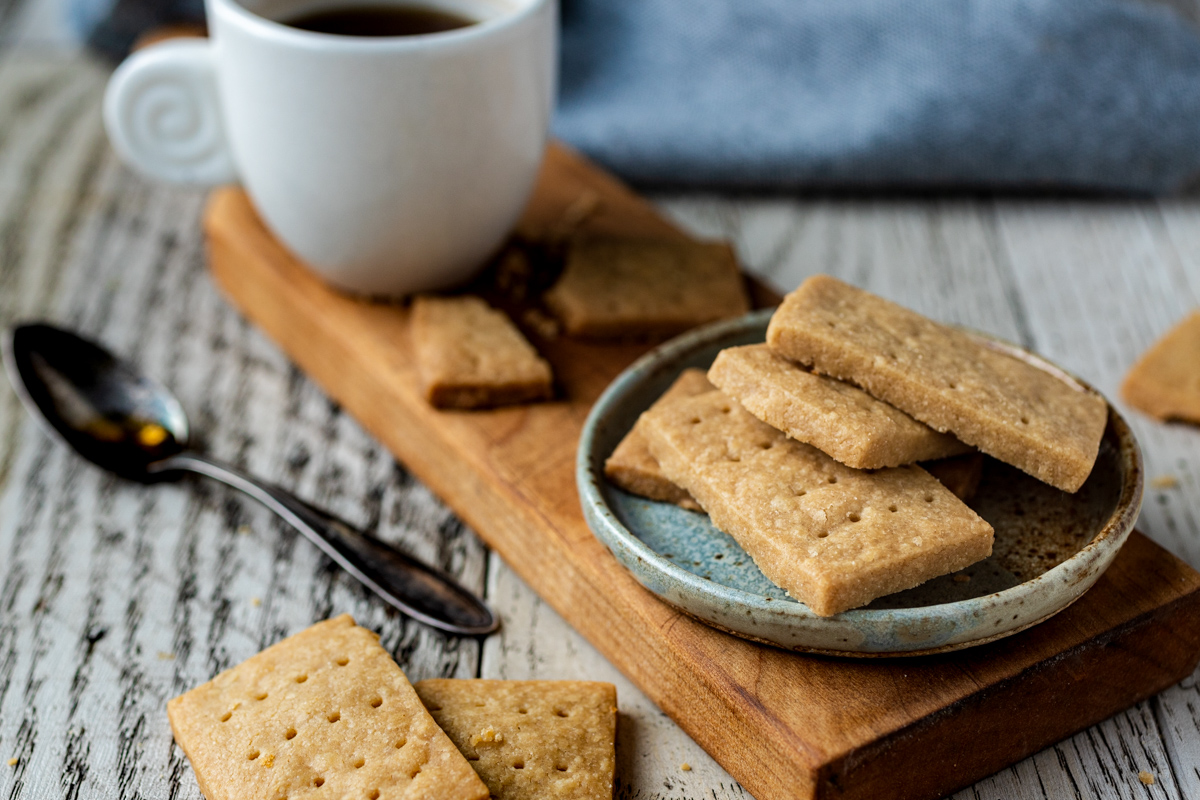 3 ingredient Scotch Shortbread Cookies piles on a plate with coffee and a spoon.